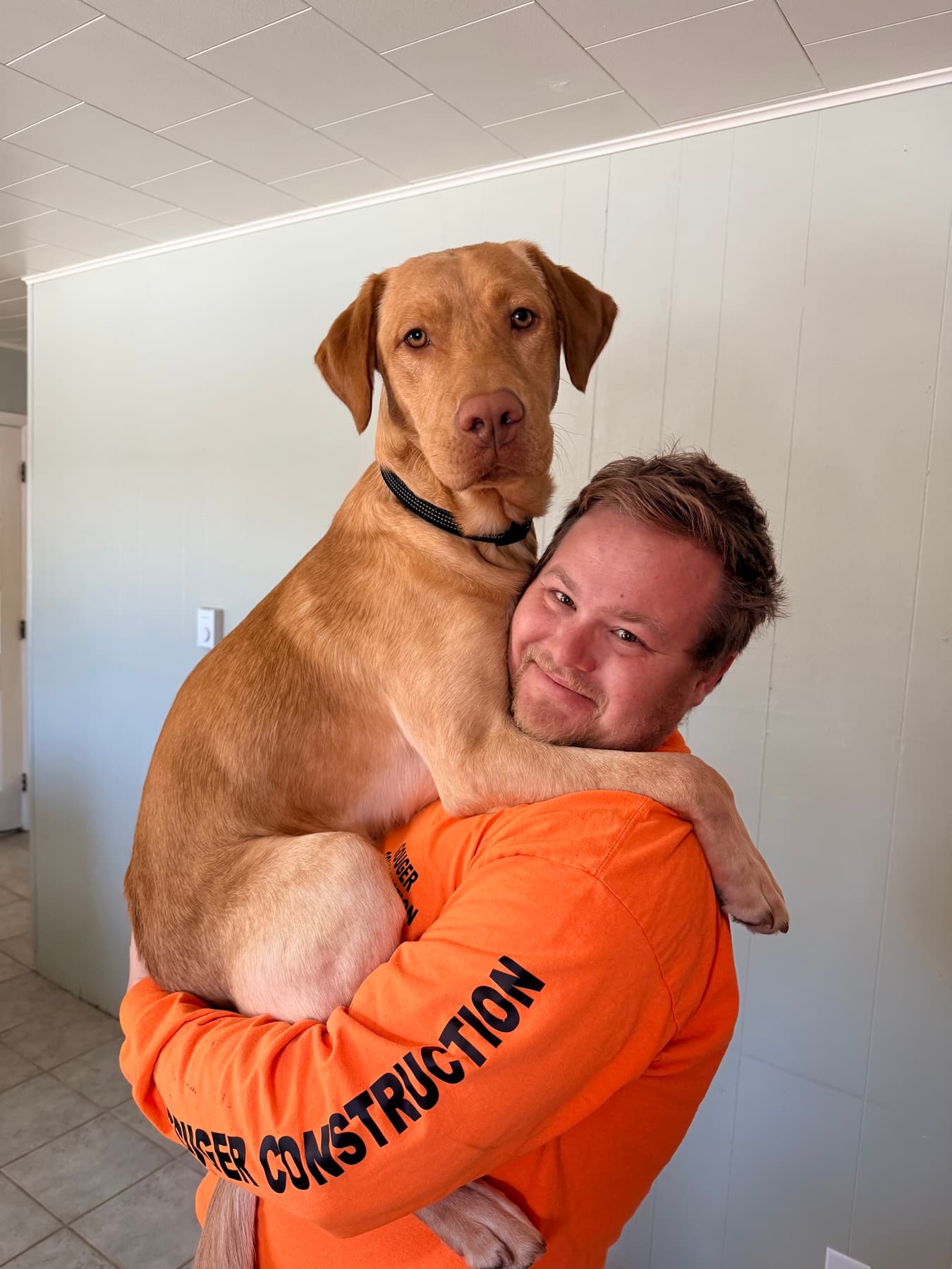 Ryan Gouger getting a full-body hug from Kash, his yellow Lab